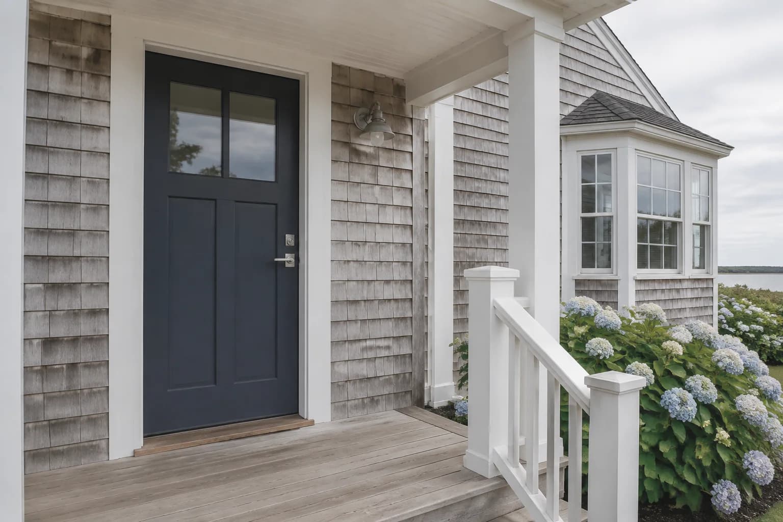 Navy front door with crisp white trim on a coastal cottage